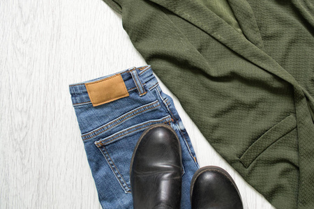 蓝色牛仔裤, 靴子和绿色夹克。细节.时尚理念