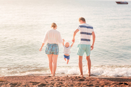 愉快的家庭与婴孩在海边海滩上