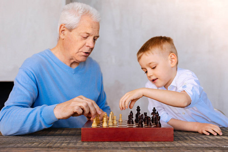 愉快的老人下棋与他的孙子