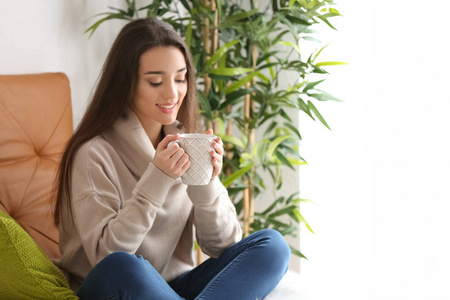 家中有杯热茶的美丽年轻女子