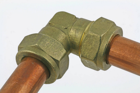 铜管道两段铜管连接到在浅蓝色背景下隔离的压缩弯头照片