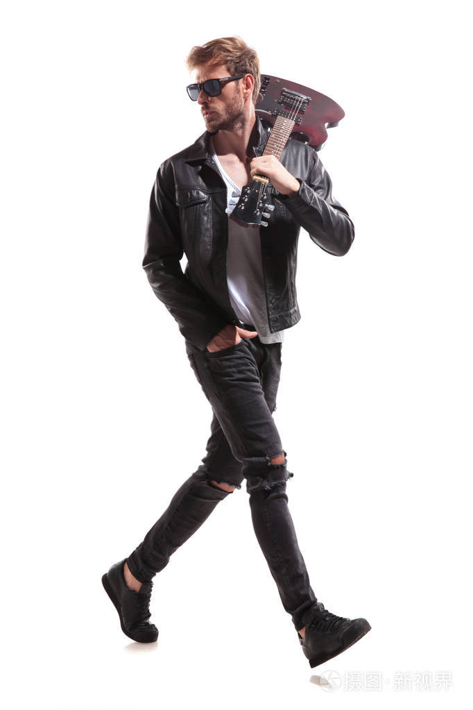 放松的吉他弹奏者的侧面观看在白色背景上, 并在他的肩膀上拿着他的电