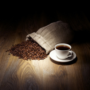 用粗麻布袋咖啡豆仿古桌上的杯咖啡