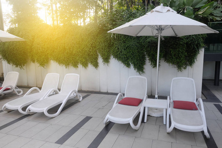 日光浴在泳池附近的椅子理想的旅行和度假概念