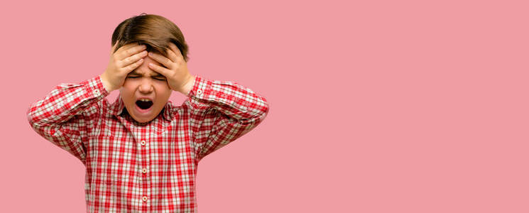 英俊的蹒跚学步的孩子与绿色的眼睛压力保持双手头上, 吓坏了, 在惊慌