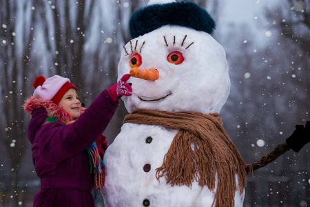 一个可爱的小女孩在冬季公园里玩得很开心, 冬天快乐素食日概念背景
