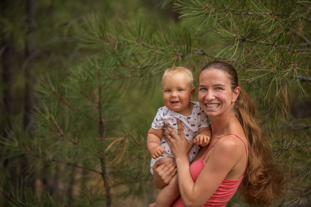 一个女人与她的儿子在绿色松林的肖像