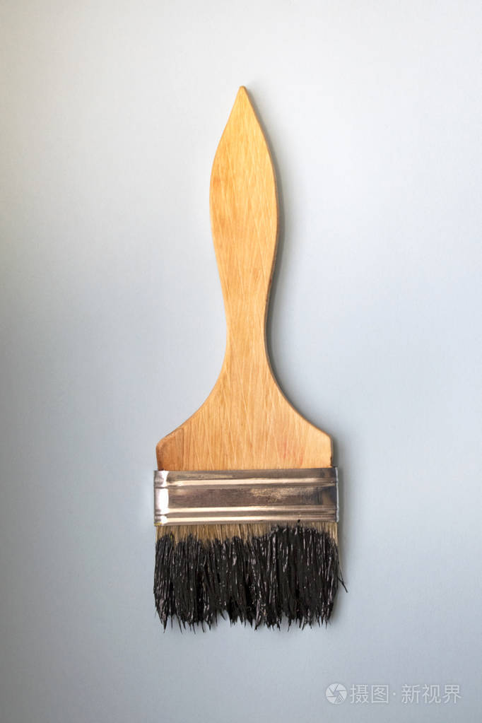 蓝色背景的木制刷子.黑色油漆
