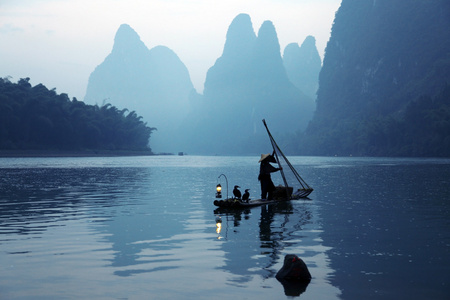 海滩上空飞过海面的鸬鹚鸟在中国使用 tra 捕鱼船与鸬鹚鸟,传统中国人