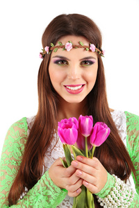 年轻漂亮的女孩与持有束鲜花，在白色孤立她头上的装饰花环