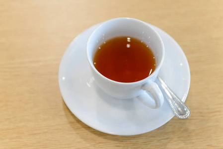 一杯热茶和勺子放在会议室的木桌上