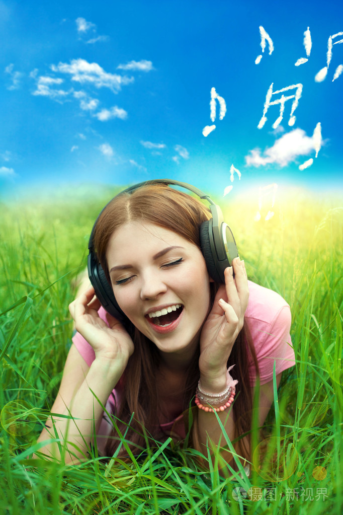 女孩唱歌和听音乐的耳机在蓝蓝的天空