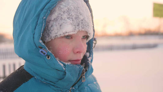 一个少年在冬季公园, 脸部特写。日落的时间。在清新的空气中漫步。健康的生活方式