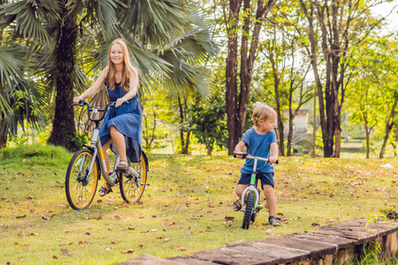 母亲和儿子骑自行车户外和微笑