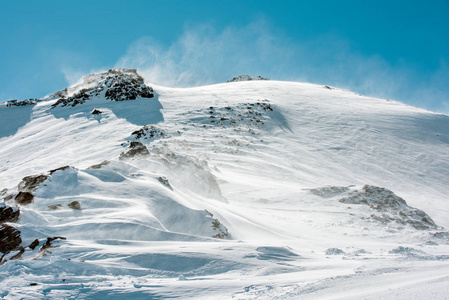 山风景。白雪覆盖的山顶对万里无云的蓝天