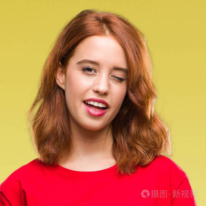 年轻美丽的女人在孤立的背景眨眼看着相机与性感的表情