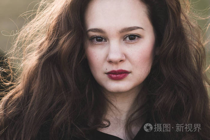 美丽的女人在户外的严重肖像, 她的头发柔软的阳光