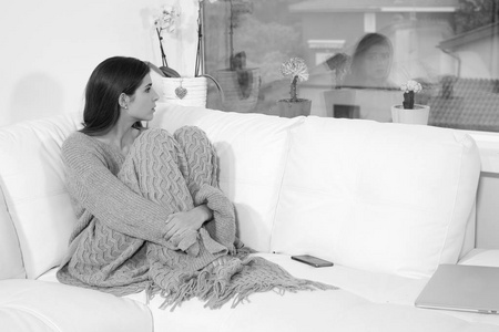 女人心悲伤寂寞的女人在家里的冬天沉思心碎的黑白色看窗外照片