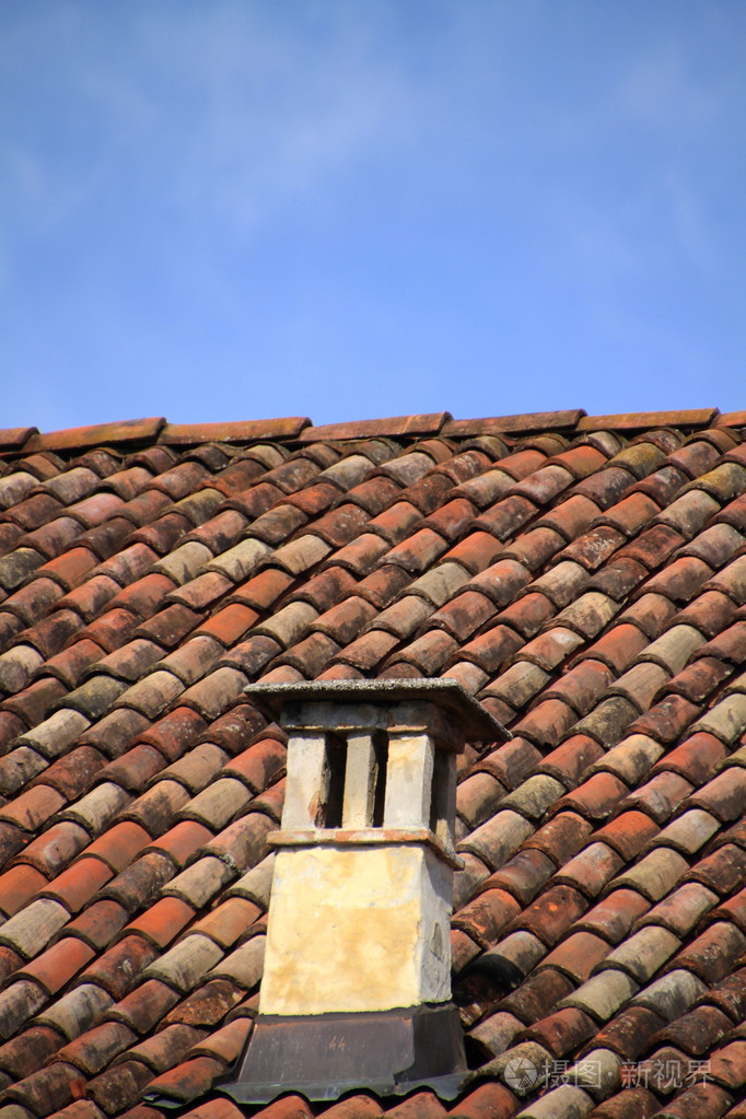 瓦屋顶上的红砖烟囱