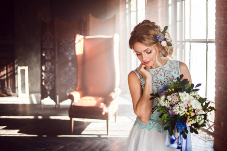 年轻漂亮的女人在婚纱礼服与花束的花朵。婚礼发型, 鲜花在发