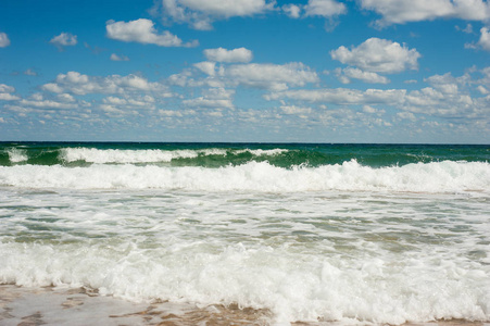 在保加利亚索佐波尔岸边的沙滩上, 海浪大破。美丽的海浪在明亮的夏日里用金色的沙子洗涤海滩