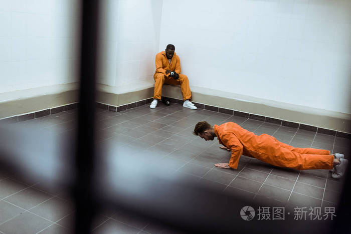监狱牢房里的犯人在地板上做俯卧撑