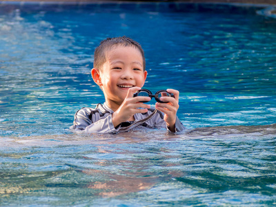 小亚洲男孩在游泳衣与护目镜图片