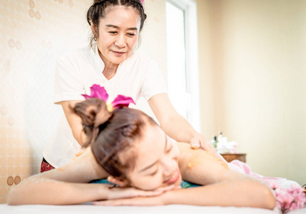 泰国水疗治疗师正在给一个女人背部皮肤擦洗
