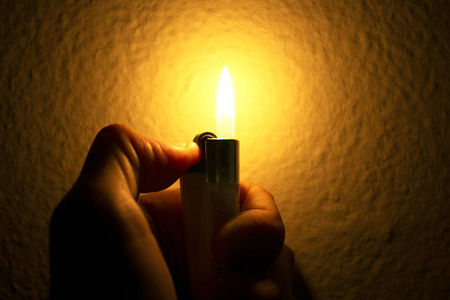 手与打火机点燃火花照片