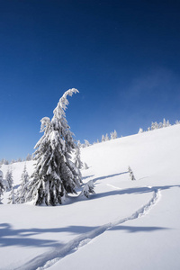 美丽的冬天风景与足迹在雪。山上晴朗的天气