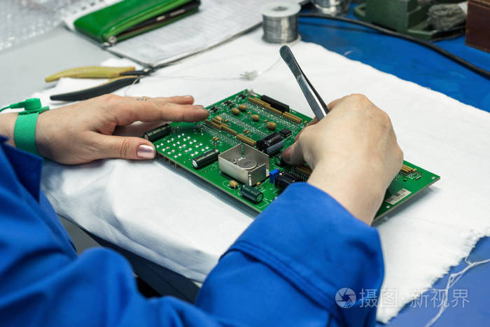 组装电子模块的过程.工人们把电子元器件放在印刷电路板上