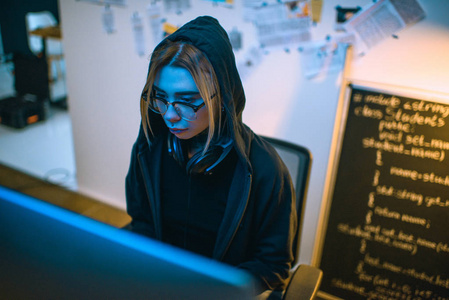 蓝光下女性黑客发展恶意软件的视角照片