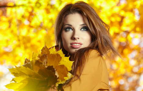 秋天的叶子的年轻女人