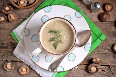 美味的健康汤与新鲜和干蘑菇在一个老木背景杯