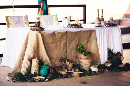 用粗麻布树桩蜡烛绿色植物装饰乡村风格的婚礼桌
