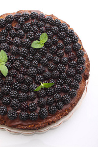 在白色背景下自制的坚果和黑莓巧克力蛋糕