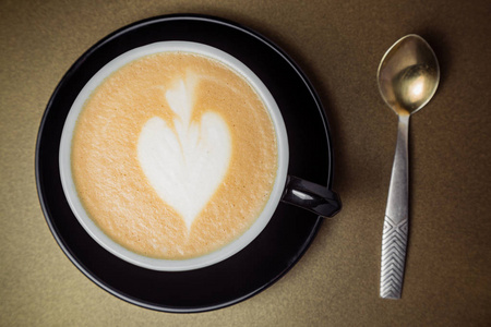 黑陶杯咖啡配奶油看起来像鹿, 勺子照片