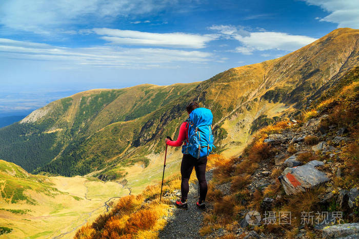 运动的徒步旅行妇女与背包在高山远足小径, Fagaras 山, 喀尔巴阡山, 罗马尼亚, 欧洲