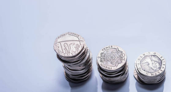 白色背景下的不同英国硬币栈