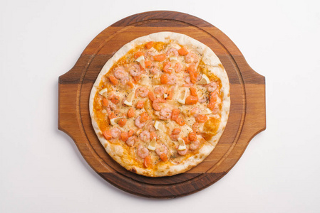 顶级比萨配番茄酱, 芝士, 虾, 鲑鱼和柠檬片, 配上木制披萨盘