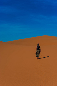 在沙丘沙漠, 撒哈拉沙漠附近, 摩洛哥的女孩散步