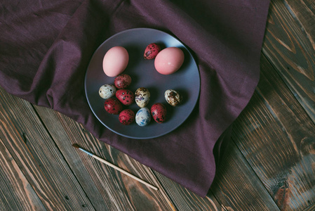 复活节彩蛋与亚麻布在一个质朴的棕色木桌上。假日背景