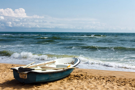 沙滩上的老划船。刮风的天气, 海浪在海里