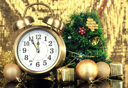在明亮的背景上的时钟和圣诞装饰品的组成