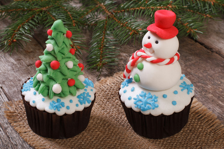 两个圣诞蛋糕 圣诞树和雪人站在桌子上
