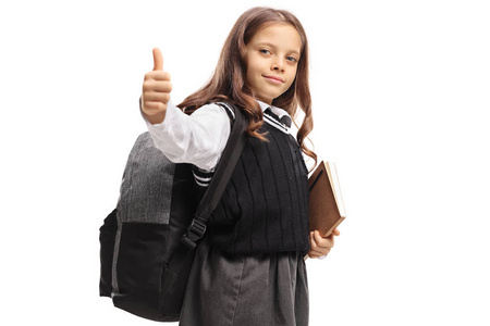 一个背包和一本书的女孩在白色背景上的拇指向上的手势隔离