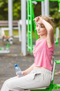 女子与瓶水休息。健身