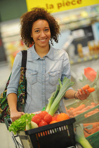 女人买蔬菜和食品在超市图片