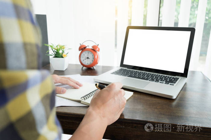 年轻的白种人在家工作计划工作写笔记在一些项目与他的笔记本电脑在