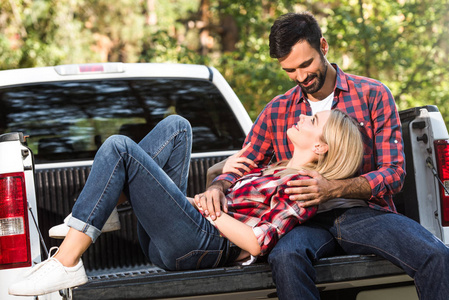 女性在汽车主干上躺在男友膝上的选择性聚焦